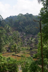 A traditional Indonesian village surrounded by mountains and rice fields called Kampung Naga. 