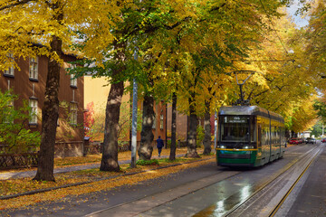 Tram in European city in autumn: wooden historic houses in Helsinki, Kapyla. - obrazy, fototapety, plakaty