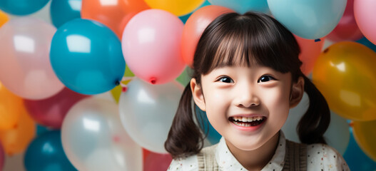 Fototapeta na wymiar Happy little girl with balloons. Birthday party celebration.