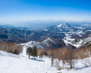 Steep ski slope with the view of snowy peaks (Ryuo, Nagano, Japan)