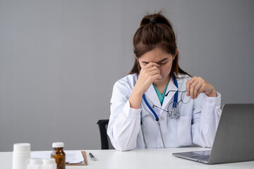 Young woman female doctor stressed angry unhappy overworked overtime fatigue at office clinic...