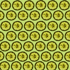 Fresh lemon slices against light green background forming a beautiful wallpaper texture pattern background.