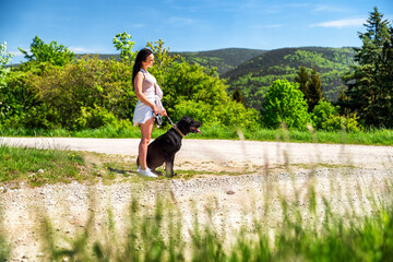 Girl with black dog waiting on the road