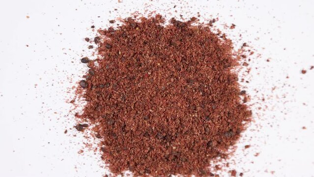 Dried ground staghorn sumac berries spinning clockwise - shallow depth of field