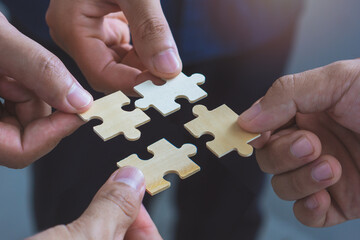 Unity concept.Business poeple merging jigsaw puzzle togather to represent Partnership and teamwork.
