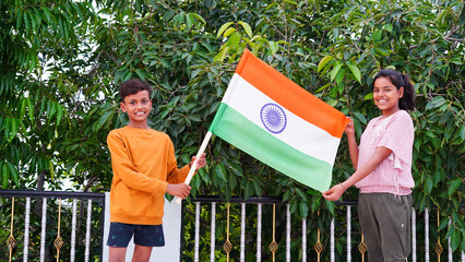Two Indian child celebrating Independence or Republic day, Cute little Indian child holding, waving...