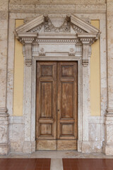 Ancient wooden portal with stone arch of a Gothic building