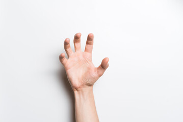 Close-up of a man's hand holding with his fingers an invisible object or item for a copy space with an advertisement on a white background.