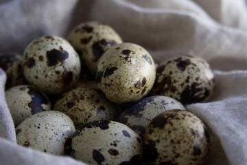 Naklejka na ściany i meble Spotted quail eggs on linen fabric close-up
