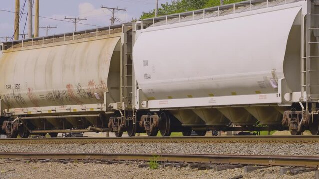 a train pulling white hopper cars rolling along the railroad tracks in the rust belt of Youngstown, Ohio