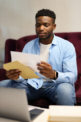 Young black man looking through financial information.