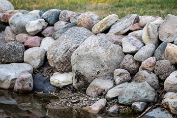 A shoreline reinforced with boulders. Erosion and landscaping