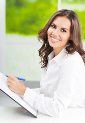 Portrait of young happy smiling business woman working with documents at office
