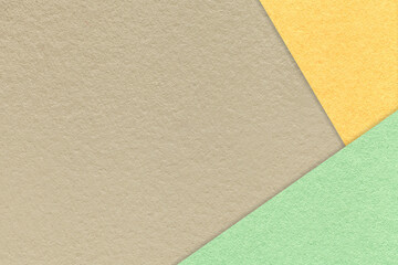 Fototapeta na wymiar Texture of craft beige color paper background with yellow and green border. Vintage abstract light brown cardboard.