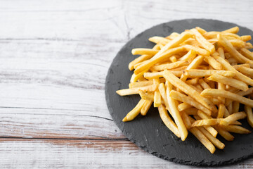 Fried potatoes, french fries on wooden table. Copy space