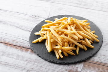 Fried potatoes, french fries on wooden table