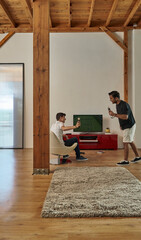 Two man playing console game in the chalet home interior style.