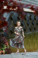 Beautiful young girl in the park by the pond