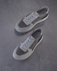 Modern street shoes stand stone on stone against a gray background