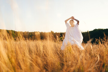 Fototapeta na wymiar Brunette young woman in wild field. Natural beauty and romance concept. Sunset light.