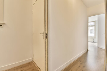 an empty room with wood floors and white walls, there is a large mirror on the wall to the right
