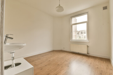 an empty room with wood flooring and light fixtures on the window sis in front of the bathroom sink