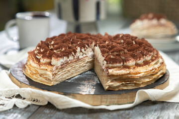 Freshly prepared delicious tiramisu crepe cake on the table.
