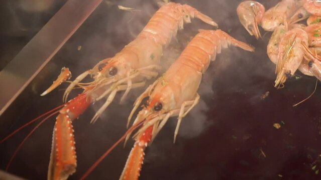 Chef cooking Norway lobster or Dublin Bay prawns or shlobster (shrimp-lobster) or langoustine or scampi at Bergen Fish Market located at the City's harbor