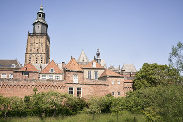 Fototapeta na wymiar Zutphen's ancient city walls with homes, gardens and the Walburgis Church