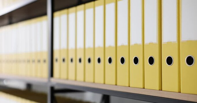 Yellow folders with folders and documents on shelves. Organized folder structure and archive on counter in modern office