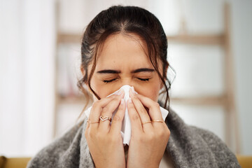 Tissue, nose and sick woman sneezing in living room with allergy, cold or flu in her home. Hay fever, sinusitis and female with viral infection, risk or health crisis in lounge with congestion - obrazy, fototapety, plakaty
