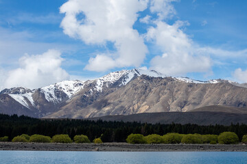 Pristine lake and snowy mountains against a blue sky.