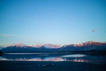 A cold sunset against a blue lake in Tekapo, New Zealand.