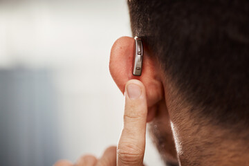 Closeup of ear, hearing aid and man with disability from the back for support, improve listening or...