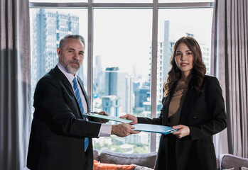 Caucasian businessman working with young Asian businesswoman in high building office