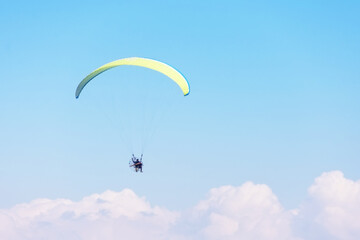 Paragliding, people take off from the beach on the ocean coast during sunny day.