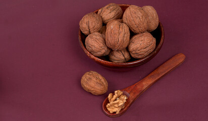 Closeup photo of a walnut seed in wooden bowl. Food that is good for brain and lower risk of heart disease.