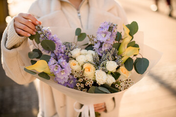 Bright wedding bouquet of roses, calla lilies,delphinium and others with eucalyptus branches in...