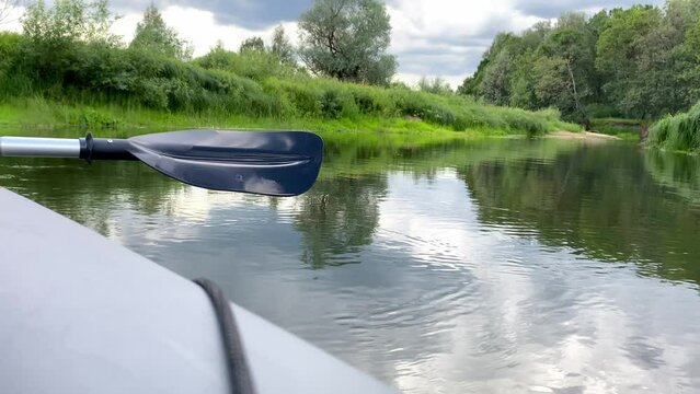 Close-up of plastic paddle over water on river in summer.