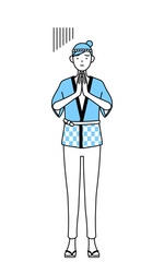 体の前で手を合わせて謝る夏祭りの法被を着た女性