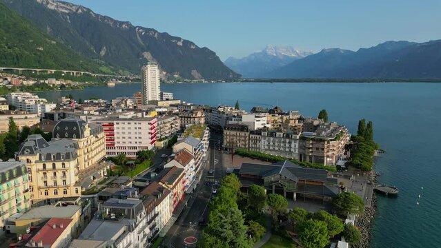 Aerial view of Montreux, Switzerland. Flying over buildings and embankment in Montreux, Lake Geneva and mountains in the background