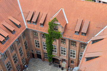 Widok na dziedziniec starego miasta wykonany z czerwonej cegły z bluszczem na fasadzie. koncepcja...