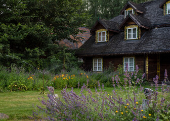 Fototapeta na wymiar Old large wooden house with beautiful grounds in a polish village. House in Podlaskie Voivodeship Style which is on Northern Poland.