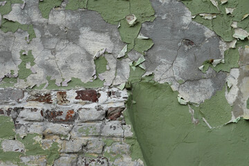 Peinture verte qui s'écaille sur un mur de briques