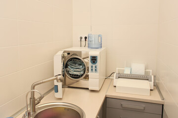 Sterilizing medical instruments in autoclave. Dental office. Selective focus. Sterile dental tools.