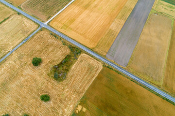 aerial view of a road between harvested agricultural fields