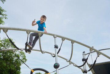 A boy child having fun daring climbs the playground