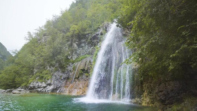 Waterfall on the mountain covered with green trees