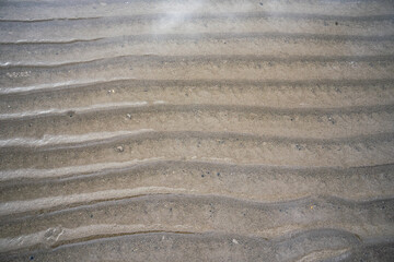 Sand texture with abstract forms of water at low tide.
