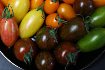a close up of multicolored tomatoes on a black plate
